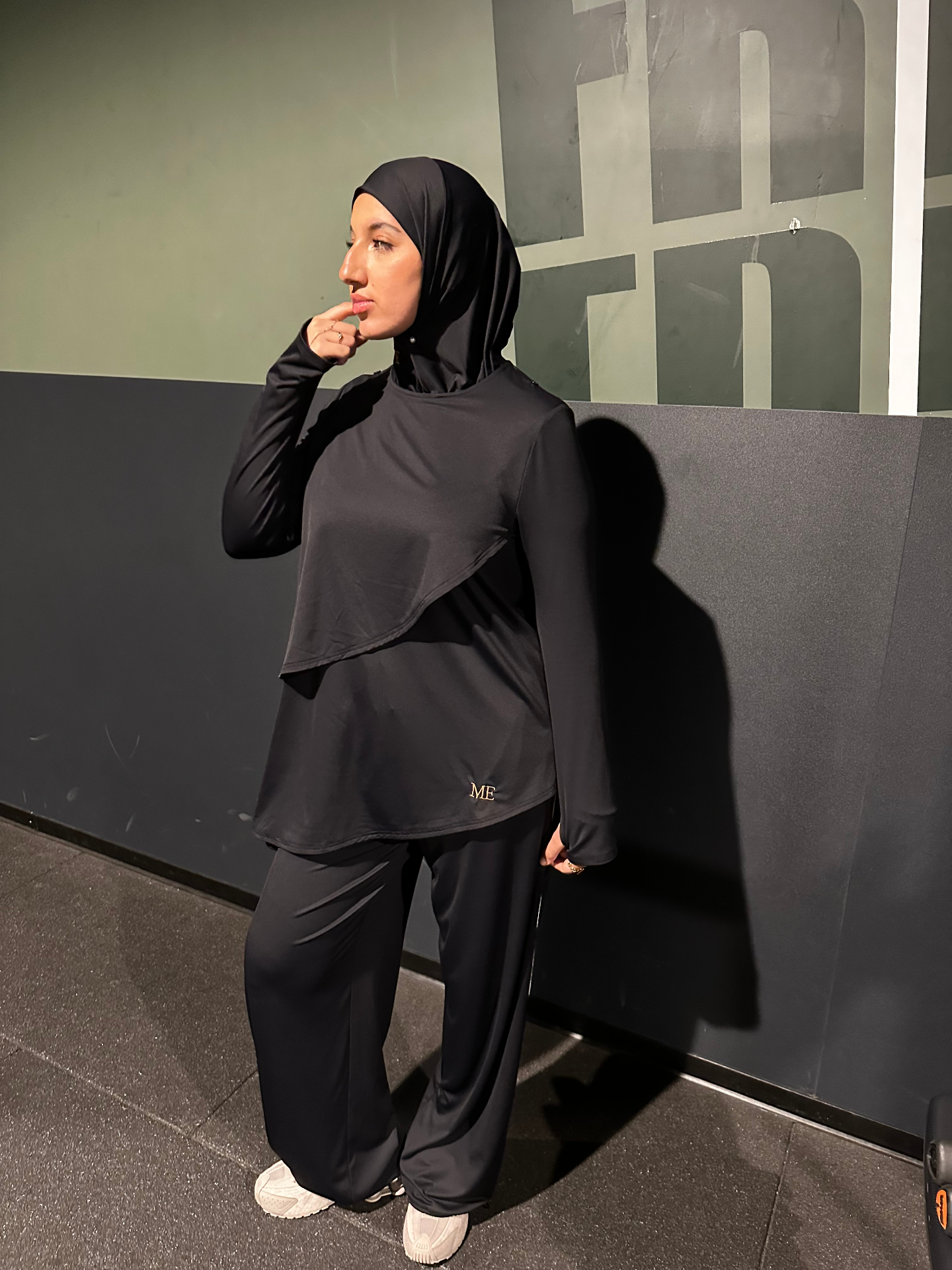 Muslim Essentials — Drop 001, haut oversize et cape fluide, assise dans l'herbe